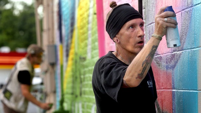 David Hoffman uses spray paint to work on a mural on the side of the building at 517 West Main Street in Murfreesboro, on Friday afternoon August  8, 2014. Russell Garrett works on the mural in the background.