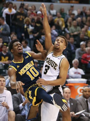 Michigan Wolverines' Derrick Walton Jr. is fouled by the Purdue Boilermakers' P.J. Thompson during first half action on Saturday, March 12, 2016 at Bankers Life Fieldhouse in Indianapolis.