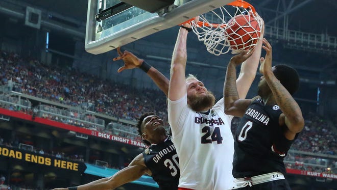 Gonzaga center Przemek Karnowski (24) slam dunks the ball while being guarded by South Carolina forward Chris Silva (30) and South Carolina guard Sindarius Thornwell (0) during the second half of the NCAA Final Four semifinals at the University of Phoenix Stadium in Glendale, Ariz. on April 1, 2017.