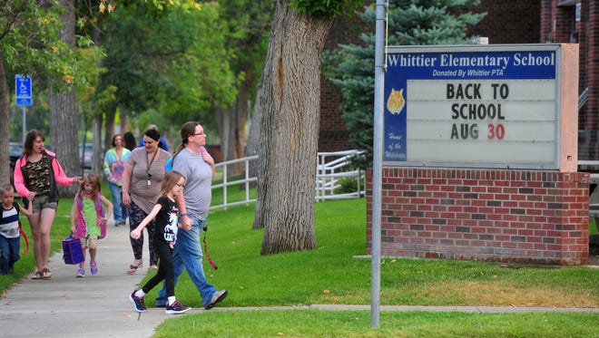 Students and their parents arrive at Whittier Elementary School for the first day of school on Wednesday morning.