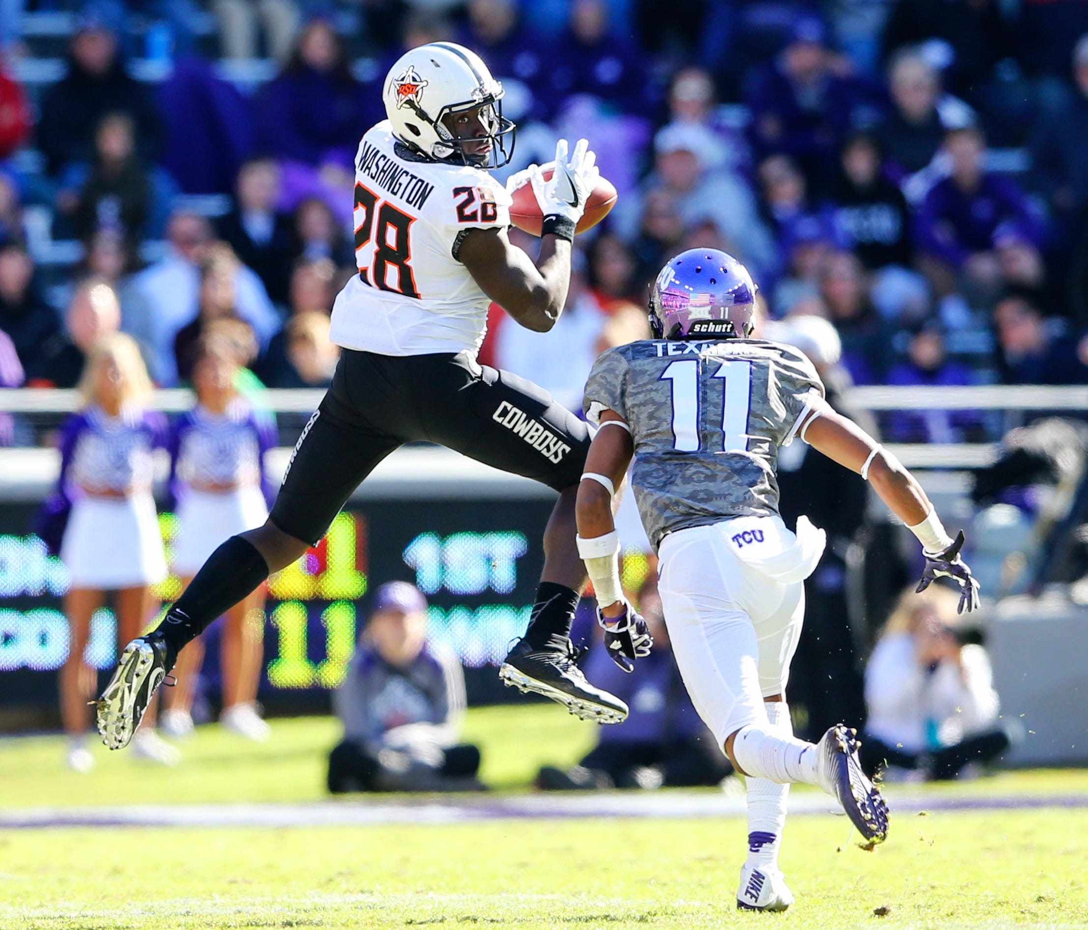Oklahoma State wide receiver James Washington makes a catch in front of TCU  cornerback Ranthony Texada during their game in 2016.