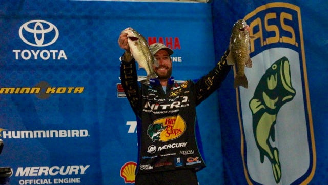 Knoxville Native Ott DeFoe hoists two of his catches during the final weigh-in of the Bassmaster Elite Series tournament in February on Cherokee Lake.