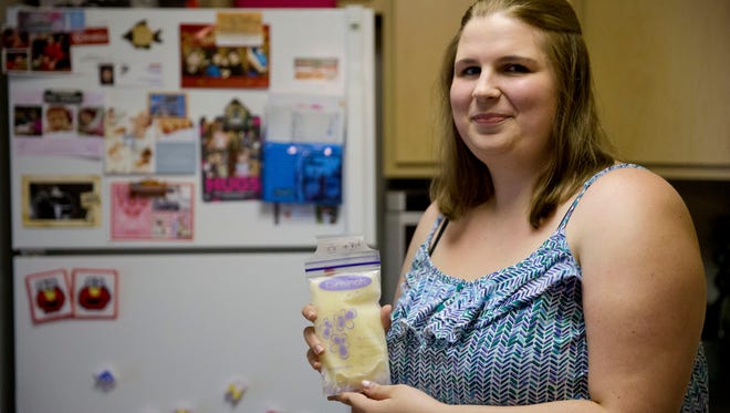 Rachel Palencik poses for a photograph with her frozen breast milk Wednesday, June 17, 2015, in West Chester, Pa. About 4,000 mothers participate in 15 nonprofit milk banks across the United States, but the entry of for-profit milk banks has led to tensions as state lawmakers begin regulating the industry.  Palencik wants to be sure that her milk goes to a mom and infant who need it.   (AP Photo/Matt Rourke)