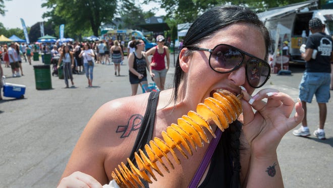 Michele Fedak of Winfield Park, NJ enjoys Salt and Vinegar Chipstix at the Jersey Shore Food Truck Festival at Monmouth Park in Oceanport, NJ on May 28, 2016