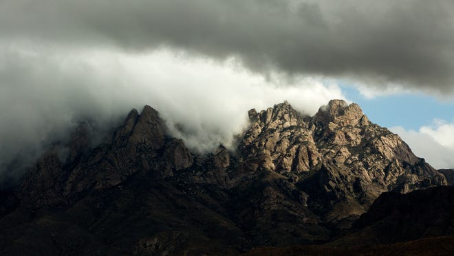 Clouds roll over the tops of the Organ Mountains as seen from the entrance of Dripping Springs Natural Area.The Organ Mountains-Desert Peaks National Monument includes the Organ Mountains, Desert Peaks, Potrillo Mountains and Doña Ana Mountains.