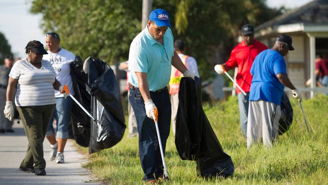 John Jones (center), of Fort Pierce, picks up trash with other volunteers during the street cleanup and block party on 14th Street between Avenue D and Avenue F hosted by the Fort Pierce Police Department, St. Lucie County Sheriff's Office, the St. Lucie County Commissioners and the City of Fort Pierce in 2013.