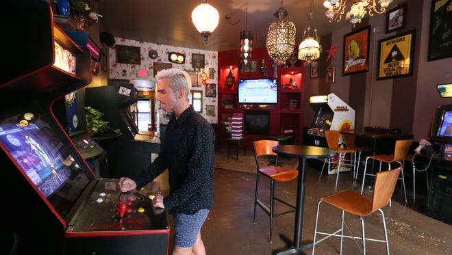 Dane Peplinski, an employee at Mary's Beercade in Milwaukee, plays a game in the arcade-themed bar. Milwaukee is growing a small group of bars that include old-school arcade games like Pac-Man and Space Invaders.