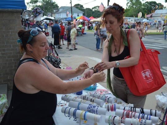 Evelyn Campbell of Jersey Handbags and Accessories sells a bracelet to Sophia McClain of Galloway during the opening night of the 140th annual Our Lady of Mount Carmel Festival in Hammonton in 2015. It is the longest running Italian festival in the country.