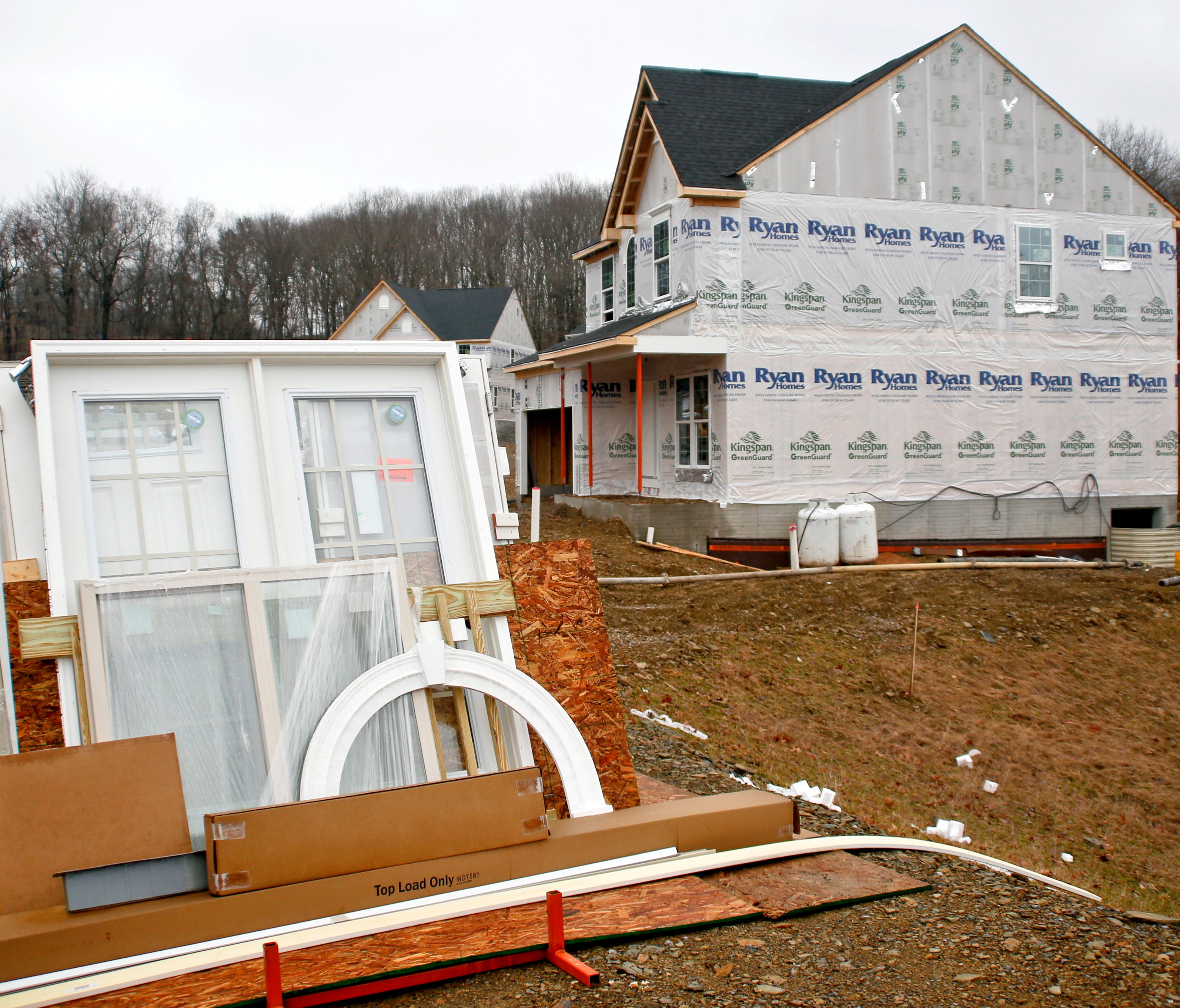 Building materials are stacked along home sites as construction is under way at a new housing plan in Zelienople, Pa. On Friday, March 16, 2018, the Commerce Department reports on U.S. home construction in February.