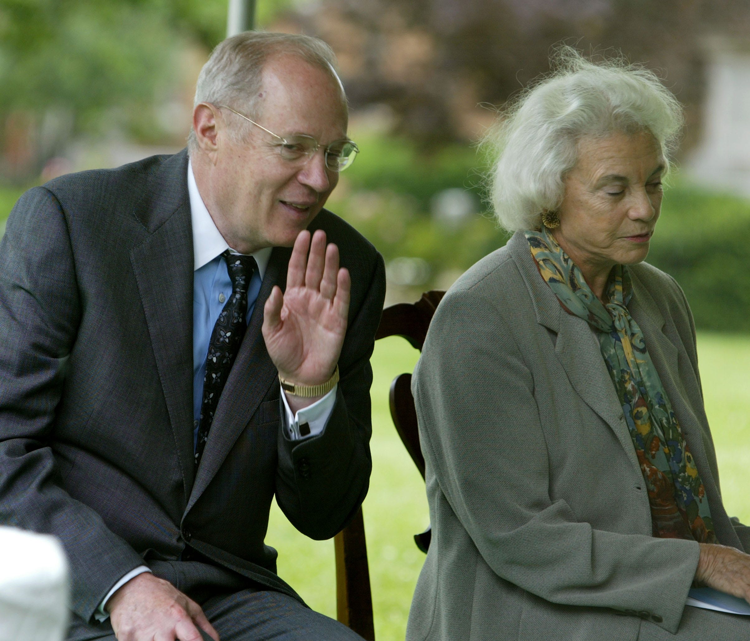 Supreme Court Justice Anthony Kennedy whispers to Justice Sandra Day O'Connor during a groundbreaking ceremony at the court in 2003.