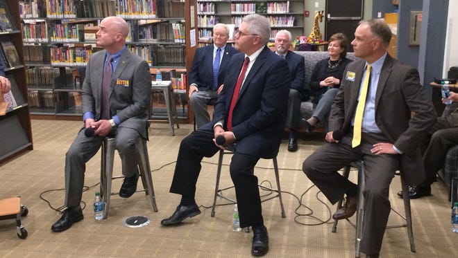 Randy Retter (from left), Donnie Benedict and Todd Barker listen to a question during Tuesday's candidate forum at the Cambridge City library.