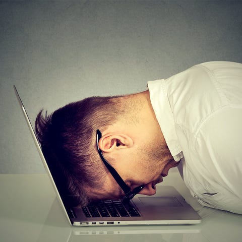 Man with head down on laptop.
