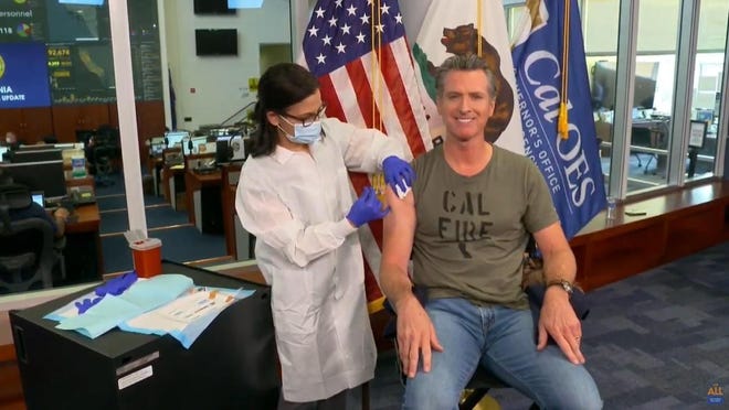 California Gov. Gavin Newsom gets a flu shot during a news conference Monday in Rancho Cordova, Calif.
