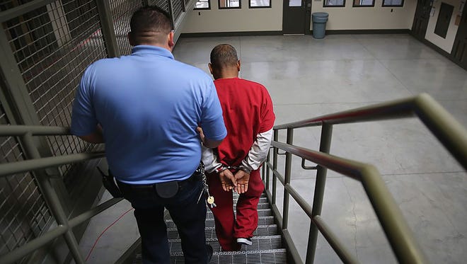 A guard escorts an immigrant detainee Nov. 15, 2013, from his segregation cell back into the general population at the Adelanto Detention Facility in Adelanto, Calif.