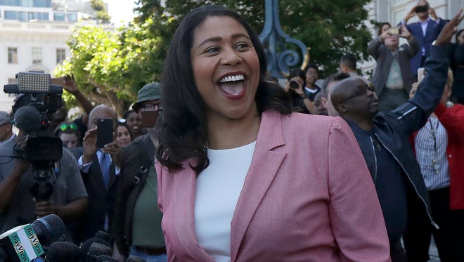 London Breed smiles toward supporters before speaking to reporters outside of City Hall in San Francisco.