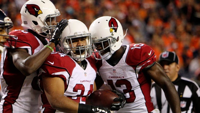 Arizona Cardinals running back Paul Lasike (34) celebrates with teammates after catching a touchdown pass during the first half against the Denver Broncos at Sports Authority Field at Mile High on Sept. 3, 2015.