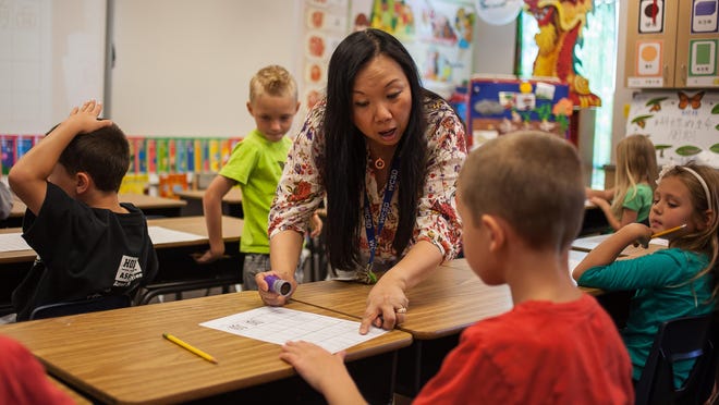 Dual language immersion teacher Waisum Buenning helps Wyatt Dutson with Mandarin Chinese classwork at Horizon Elementary School in June 2014.