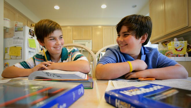 Two brothers enjoy a laugh during a homework session in Lomita, California.