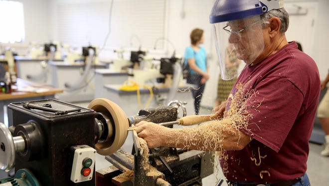 K.C. Kendall with the Ohio Valley Woodturners Guild finishes a bowl in a new studio at the Kennedy Heights Cultural Campus new building on Montgomery Road.