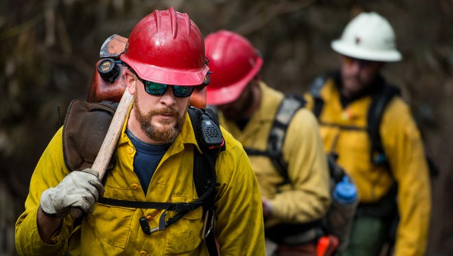 U.S. Forest Service firefighter Chad Heck, from the Colville National Forest in Washington state, hikes up the Rainbow Falls Trail in the Great Smoky Mountains National Park near Gatlinburg, Tenn., Wednesday, Dec. 7, 2016. Hundreds of firefighters continue to conduct operations within the park as the Chimney Top 2 Fire is reported to be 64% contained as of Wednesday morning. 