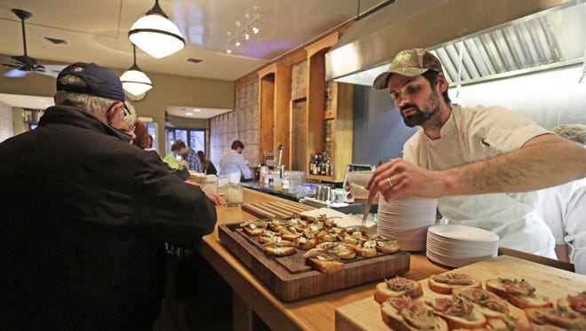 Jon Horan puts the finishing touch on a selection as Town Council Kitchen and Bar in Neenah welcomes guests during a pre-opening event.