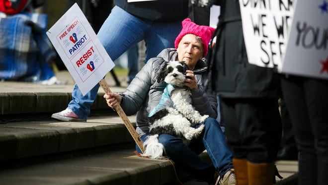 A woman wearing a "pussy" hat listens to speakers at an immigration rights rally in front of the Capitol on Sunday, Feb. 19, 2017, in Salem, Ore. Attendees called for unity and solidarity, and spoke of the contributions that immigrants have made to the United States throughout history.