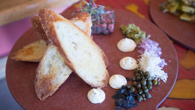 A plate of beef tartar is served with bread and sauce at Cafe Vino on Friday, March 16, 2018.