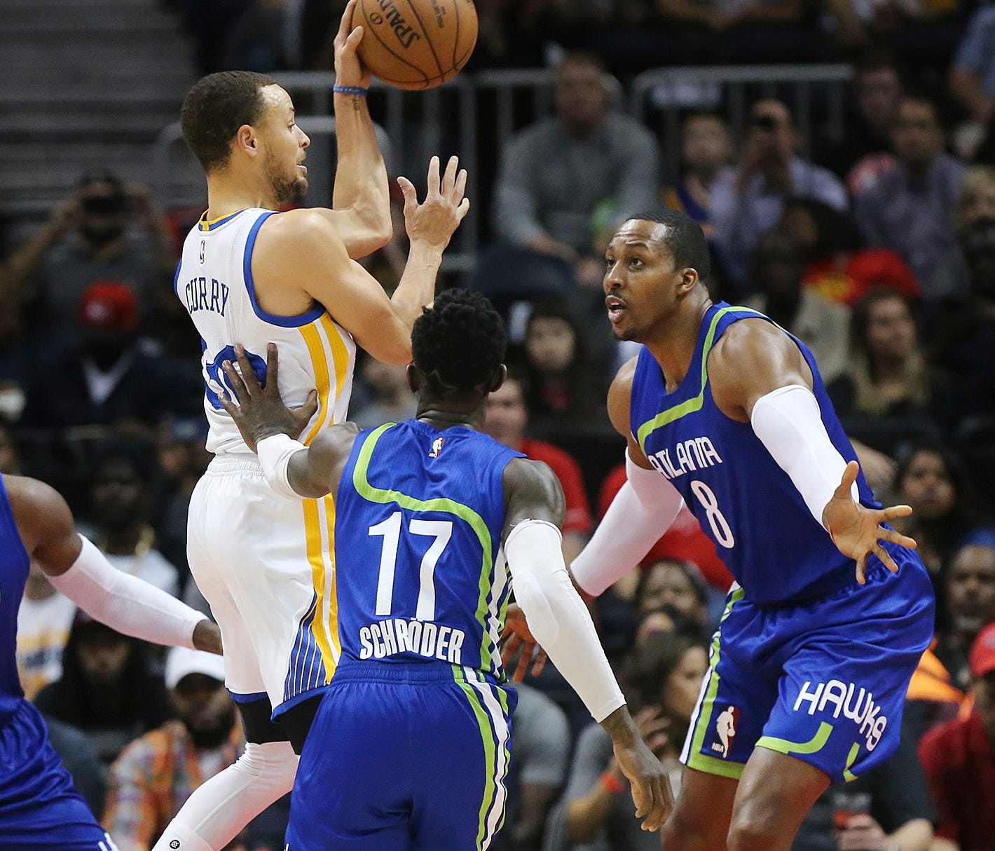 Golden State Warriors Stephen Curry passes off on a triple team by Atlanta Hawks defenders Paul Millsap (from left), Dennis Schroder, and Dwight Howard during an NBA basketball game on Monday, March 6, 2017, in Atlanta. (Curtis Compton/Atlanta-Journa