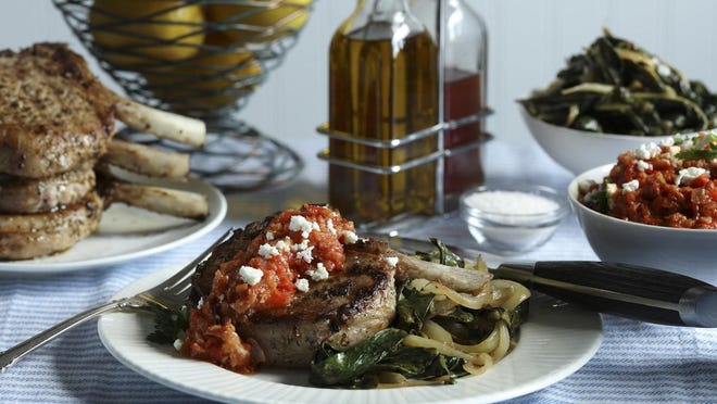 Pork chops are served with a roasted red pepper and feta cheese relish, plus a side of sauteed greens.