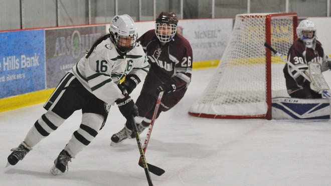 Canton's Olivia Maffeo, left, goes around Dedham's Connie Doyle during girls hockey at the Canton Ice House on Wednesday, Jan. 15, 2020. Tom Gorman/For The Patriot Ledger
