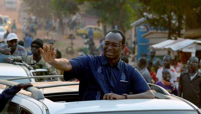 Central African presidential candidate Anicet Georges Dologuele waves from a car in a motorcarde during a presidential campaign tour in Bangui on December 28, 2015, on the last day of campaigning ahead of Central African Republic presidential and legislative elections due December 30. (Issouf Sanogo, AFP/Getty Images)