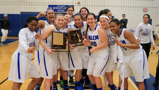 Salem’s varsity girls basketball team celebrates after defeating Plymouth in Tuesday’s conference title game.
