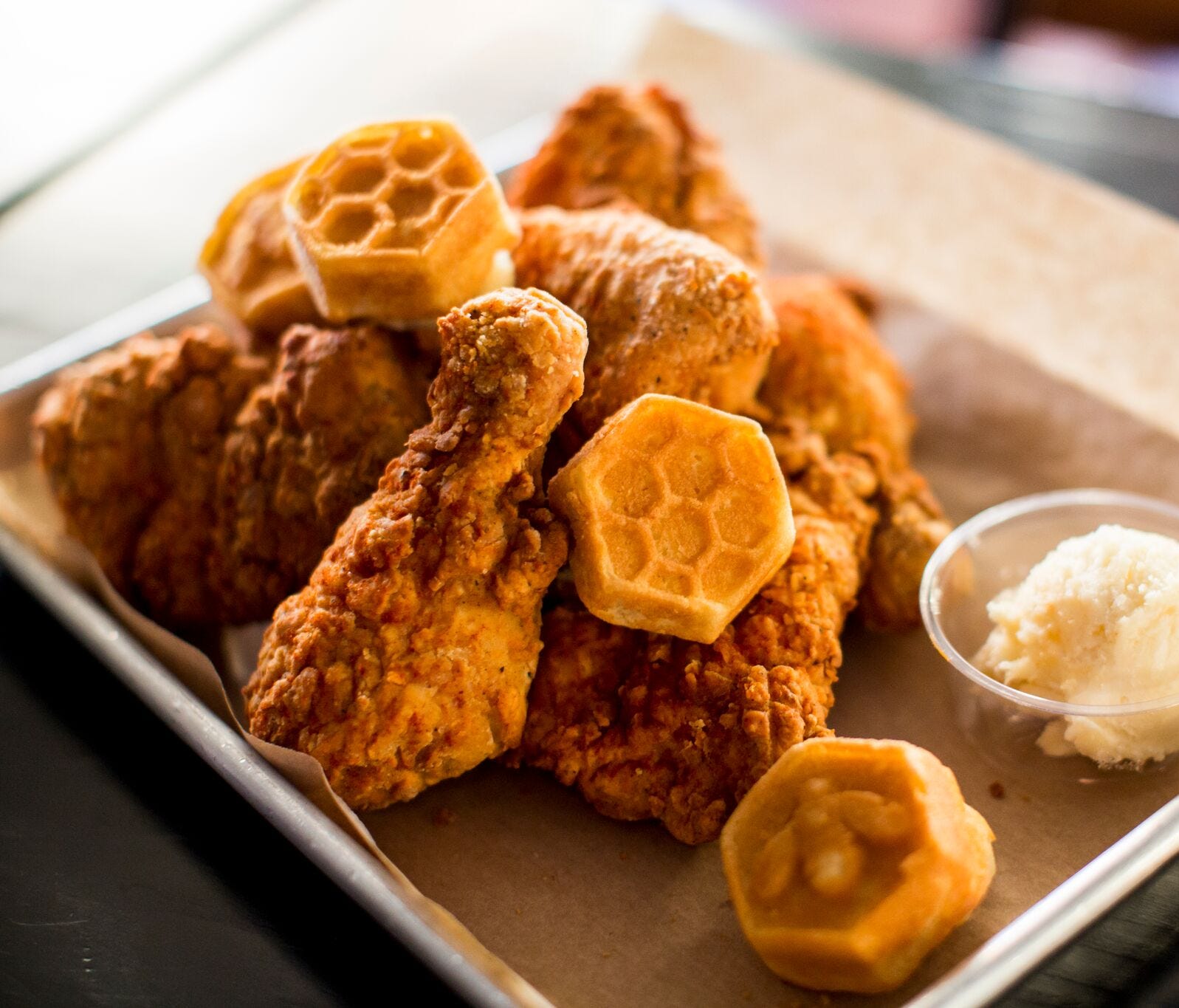 An order of the namesake fried chicken is served with mini-corn muffins and honey butter.