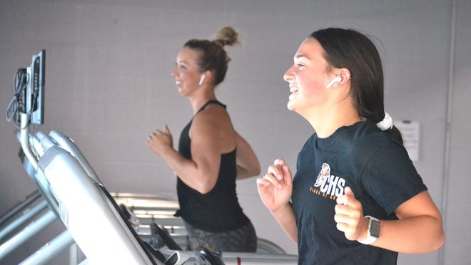 Cheboygan's Ashley Knaffle (far left) and Myia White run on treadmills at Main Street Fitness in Cheboygan on Wednesday morning. Knaffle and White were among the many thrilled to be back working out at Main Street Fitness, which had been closed since March 16 because of the coronavirus pandemic.