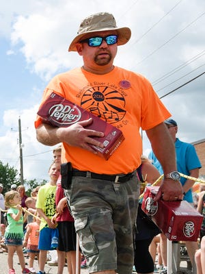 Volunteer Gary Wenner, Richmond, returned with more pop for the participants in the tractor pull during the Richmond River Lake Days on Saturday in Richmond.