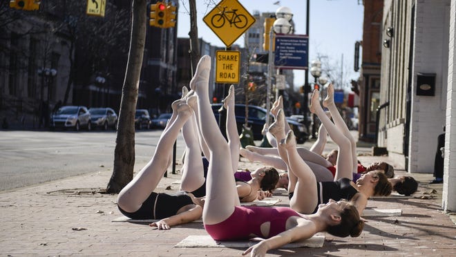 Students from CAS Ballet Theatre School stretch on the sidewalk Saturday in Ann Arbor, Mich., where it was 18 degrees above the normal high.