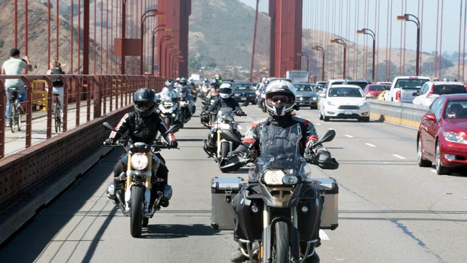 Alisa Clickenger leads women riders over San Francisco’s Golden Gate Bridge at the end of a cross-country trip to honor two sisters from Brooklyn, N.Y