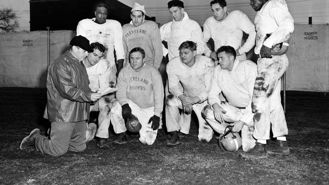 Coach Paul Brown, wearing baseball cap at lower left, poses with Cleveland Browns players, Dec. 23, 1952. At front, left to right: Dante Lavelli, Lin Houston, Frank Gatski, and George Young. Standing, left to right: Marion Motley, Otto Graham, Mac Speedie, Lou Groza, and Bill Willis. Lavelli, Gatski, Motley, Graham, Speedie, Groza and Willis all earned a spot among the top 16 players on our Browns 75th anniversary all-time team.