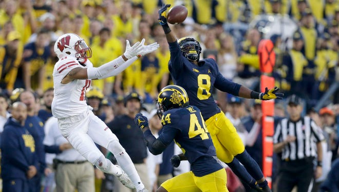 Wisconsin Badgers wide receiver Jazz Peavy has a pass broken up by Michigan Wolverines cornerback Channing Stribling (8) as safety Delano Hill assists.