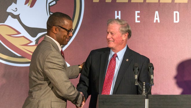 Willie Taggart, left, is greeted by Florida State University president John Thrasher before as Taggart is introduced as the Seminoles' coach during an NCAA college football news conference in Tallahassee.