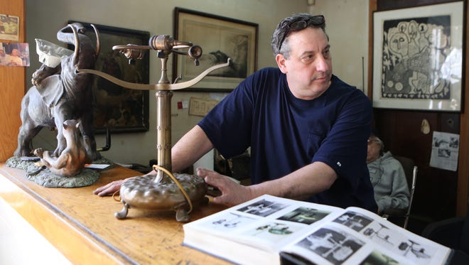 Robert Vitulli, the owner of Artcraft Silversmiths in Mount Vernon, is pictured in the shop with a brass Tiffany library base lamp.