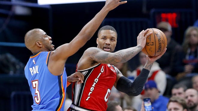 Portland's Damian Lillard (0) looks for a teammate to pass to against the defense of Oklahoma City's Chris Paul during a Jan. 18 game at the Chesapeake Energy Arena in Oklahoma City.