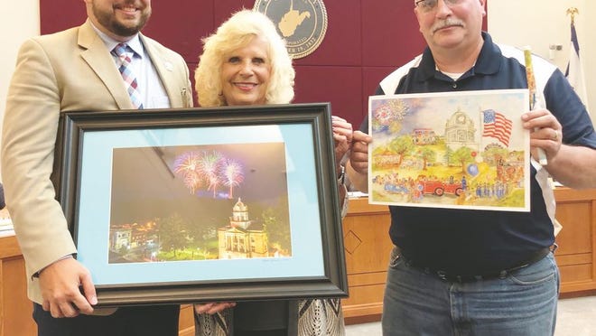 Buchannon mayor Robbie Skinner (left) presents Mayor Carolyn Rader with a Ripley Fourth of July fireworks photo. Councilman John McGinley (right) gifts Skinner with a print by former mayor and artist Willa McGinley, along with a commemorate Ripley pen.