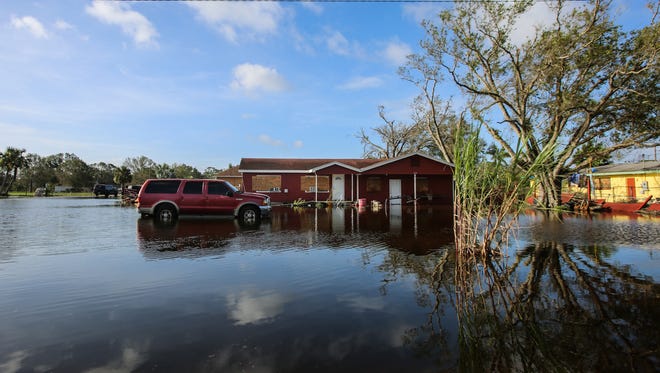 A car and house sit in high water in Immokalee Monday, Sept. 11, 2017. High winds and heavy rain from Hurricane Irma caused flooding and other damage throughout Collier County.