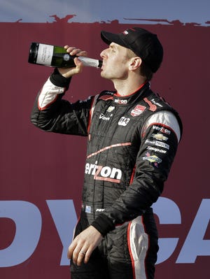 Will Power celebrates his win at the Grand Prix of St. Petersburg with a bottle of champagne.