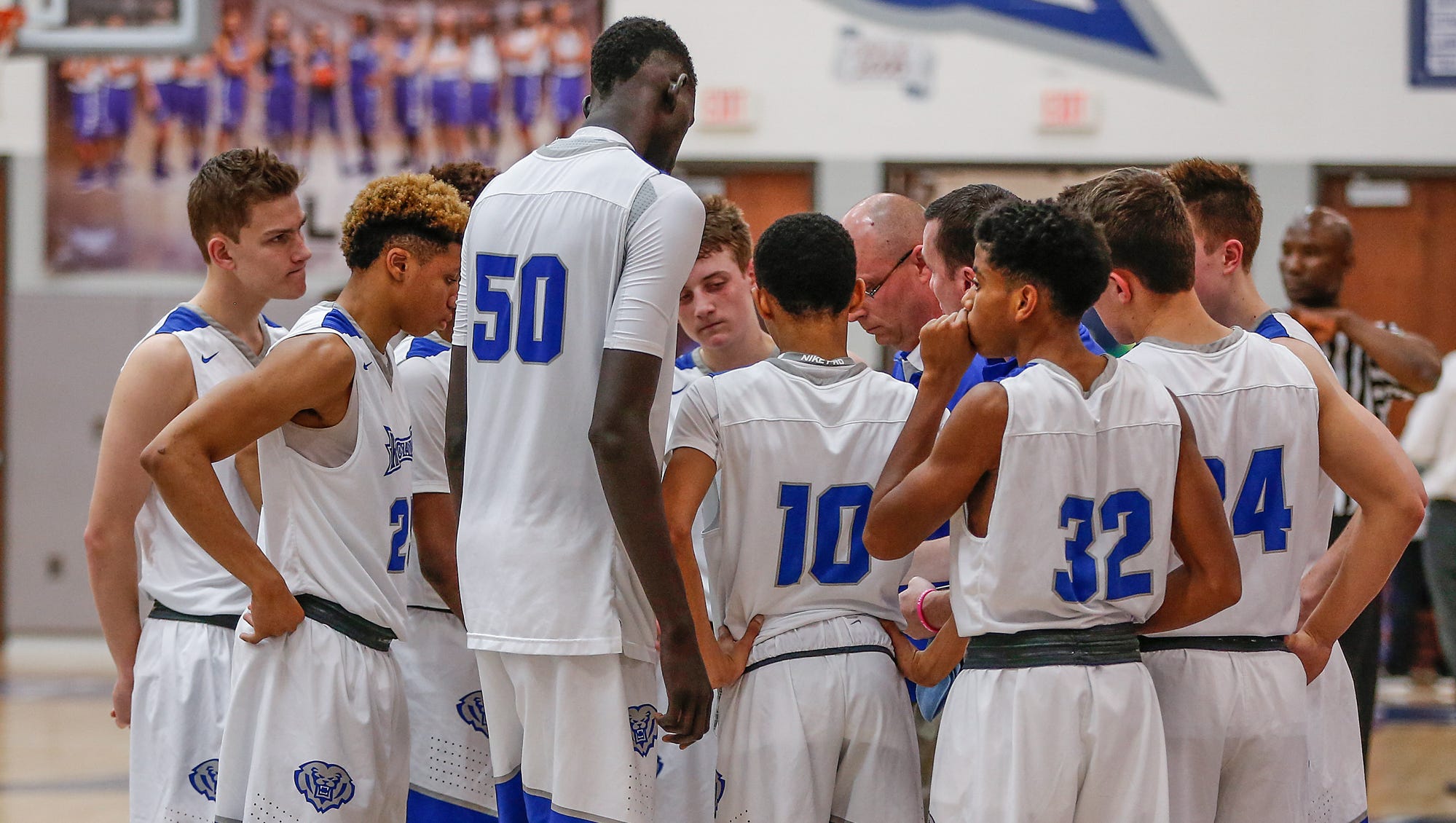 Hamilton Southeastern Royals center Mabor Majak (50) towers over his junior varsity teammates in a huddle just before tip-off against the New Castle Trojans on Tuesday, Feb. 7, 2017. Majak is freshman and stands 7 feet 1 inch tall. Mykal McEldowney/IndyStar