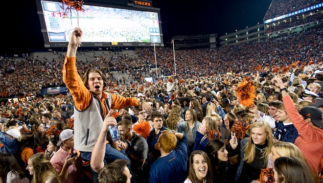 Auburn fans storm the field after Auburn defeated Alabama in the Iron Bowl in Auburn, Ala. on Saturday November 25, 2017. (Mickey Welsh / Montgomery Advertiser)