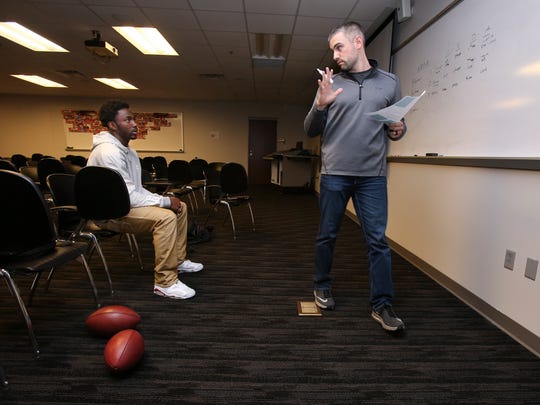 Western Kentucky University wide receiver Taywan Taylor, left, listens to Cincinnati Bengals assistant receivers coach Dan Pitcher as he discussed pass route concepts on April 6, 2017.