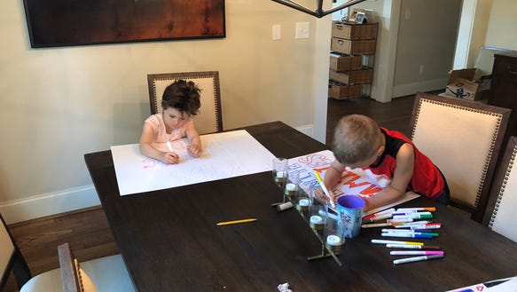 Children of 3 and 6 years of the mother of Atlanta, Shannon Cofrin Gaggero, work on signs for a lemonade stand designed to support immigrant children separated from their parents at the border.