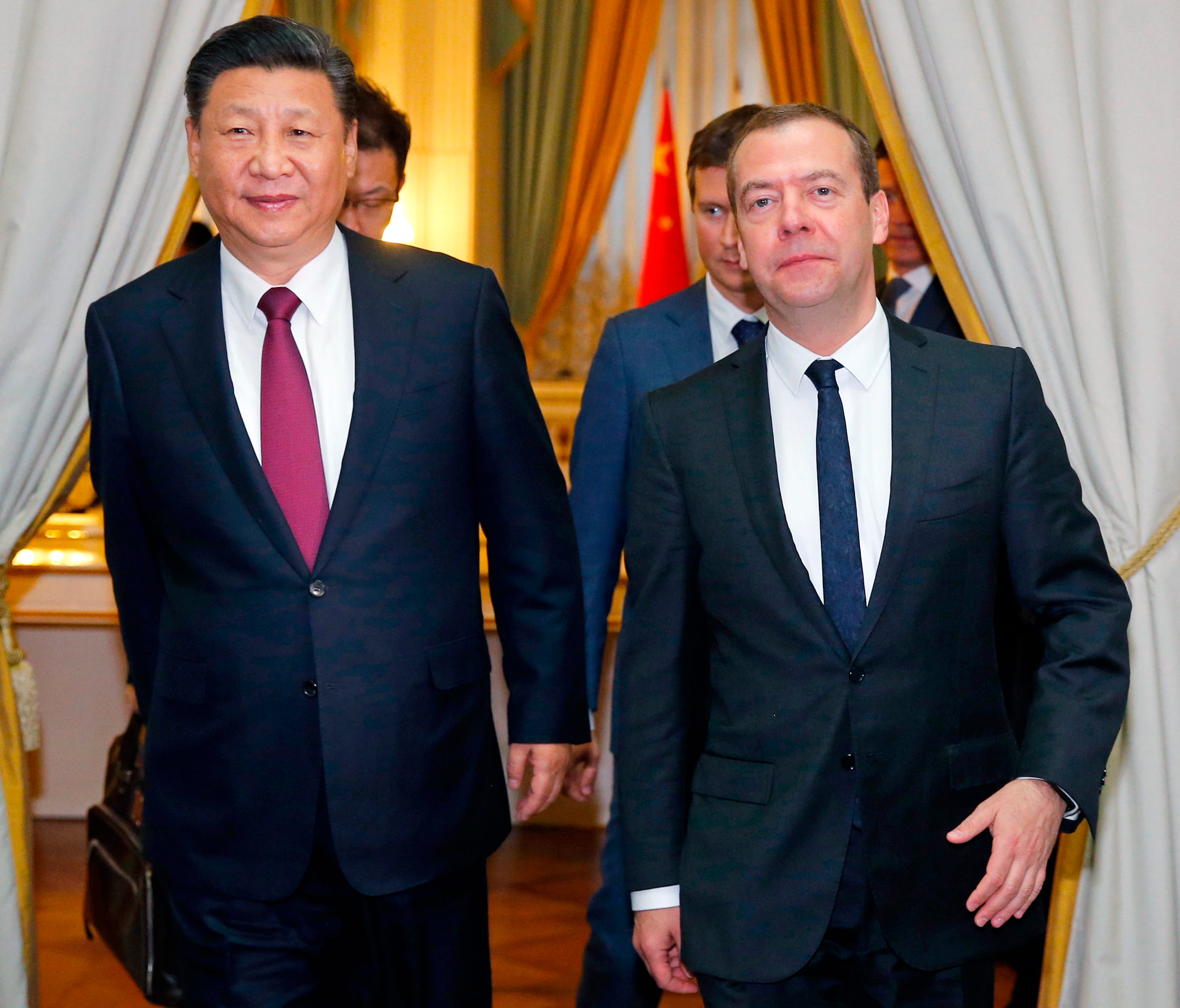 Chinese President Xi Jinping, left, and Russian Prime Minister Dmitry Medvedev walk together prior talks in Moscow, Russia, Tuesday, July 4, 2017.